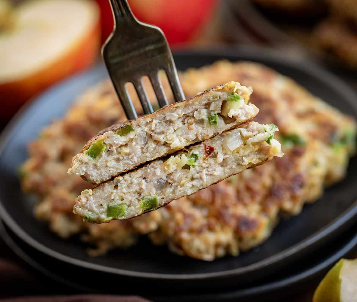 Fork with one Apple Jalapeño Breakfast Sausage Patty on it that has been halved showing the inside texture Fork with one Apple Jalapeño Breakfast Sausage Patty on it that has been halved showing the inside texture.