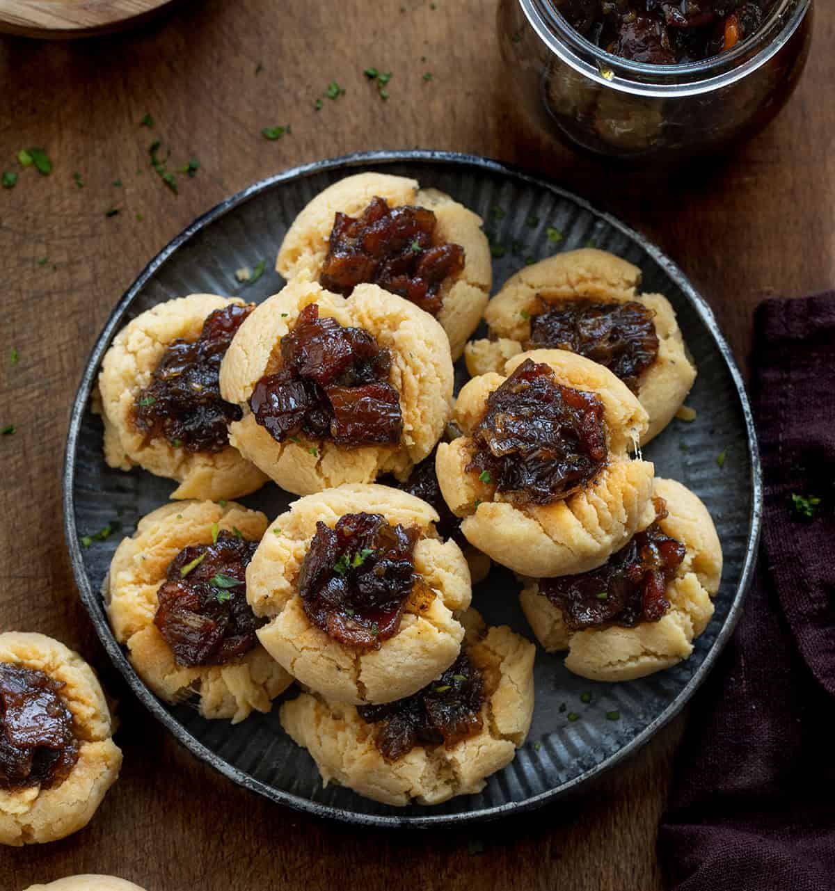 Tray of Bacon Jam Cheddar Thumbprint Cookies on a wooden table from overhead Tray of Bacon Jam Cheddar Thumbprint Cookies on a wooden table from overhead.
