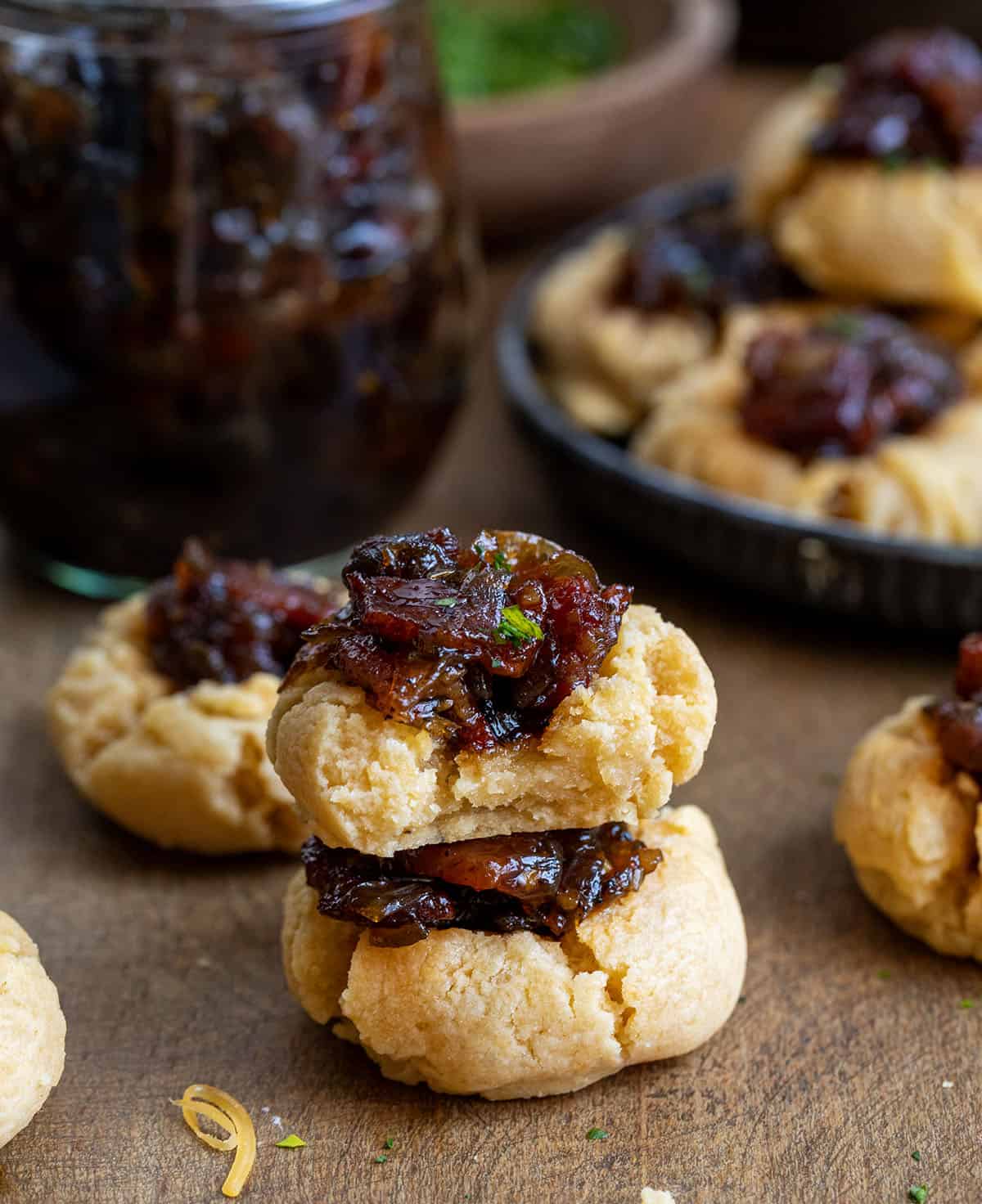 Bacon Jam Cheddar Thumbprint Cookies with the top cookie bit into showing the inside texture Bacon Jam Cheddar Thumbprint Cookies with the top cookie bit into showing the inside texture.