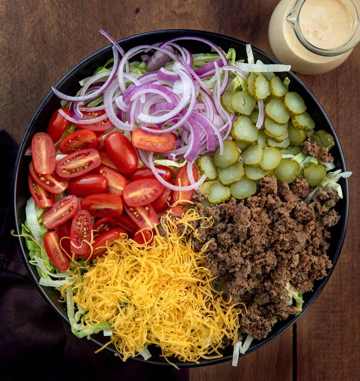 Cheeseburger Salad ingredients in a black serving bowl before being mixed with the special sauce dressing Cheeseburger Salad ingredients in a black serving bowl before being mixed with the special sauce dressing.