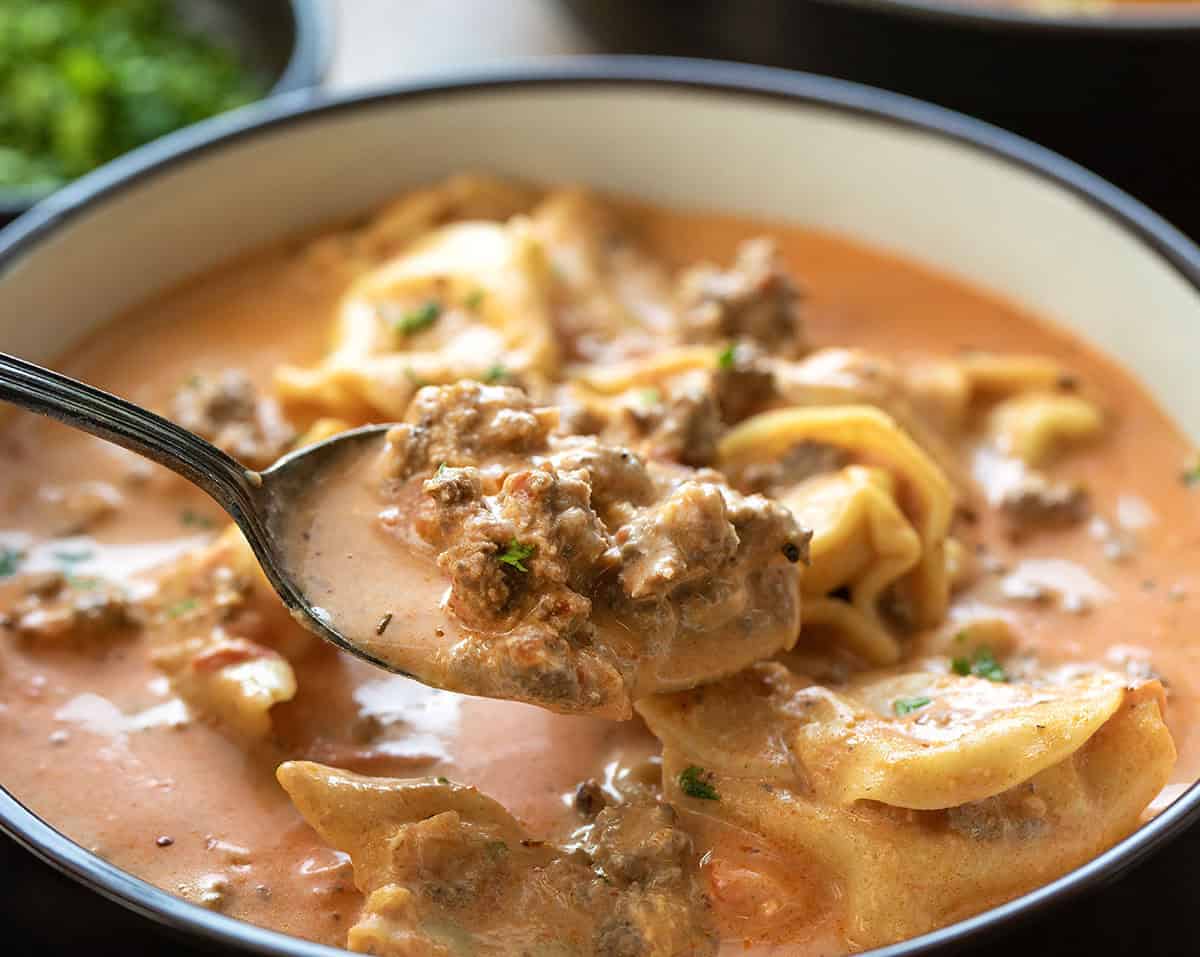 Spoonful of Cheesy Hamburger Tortellini Soup being held above the bowl Spoonful of Cheesy Hamburger Tortellini Soup being held above the bowl.