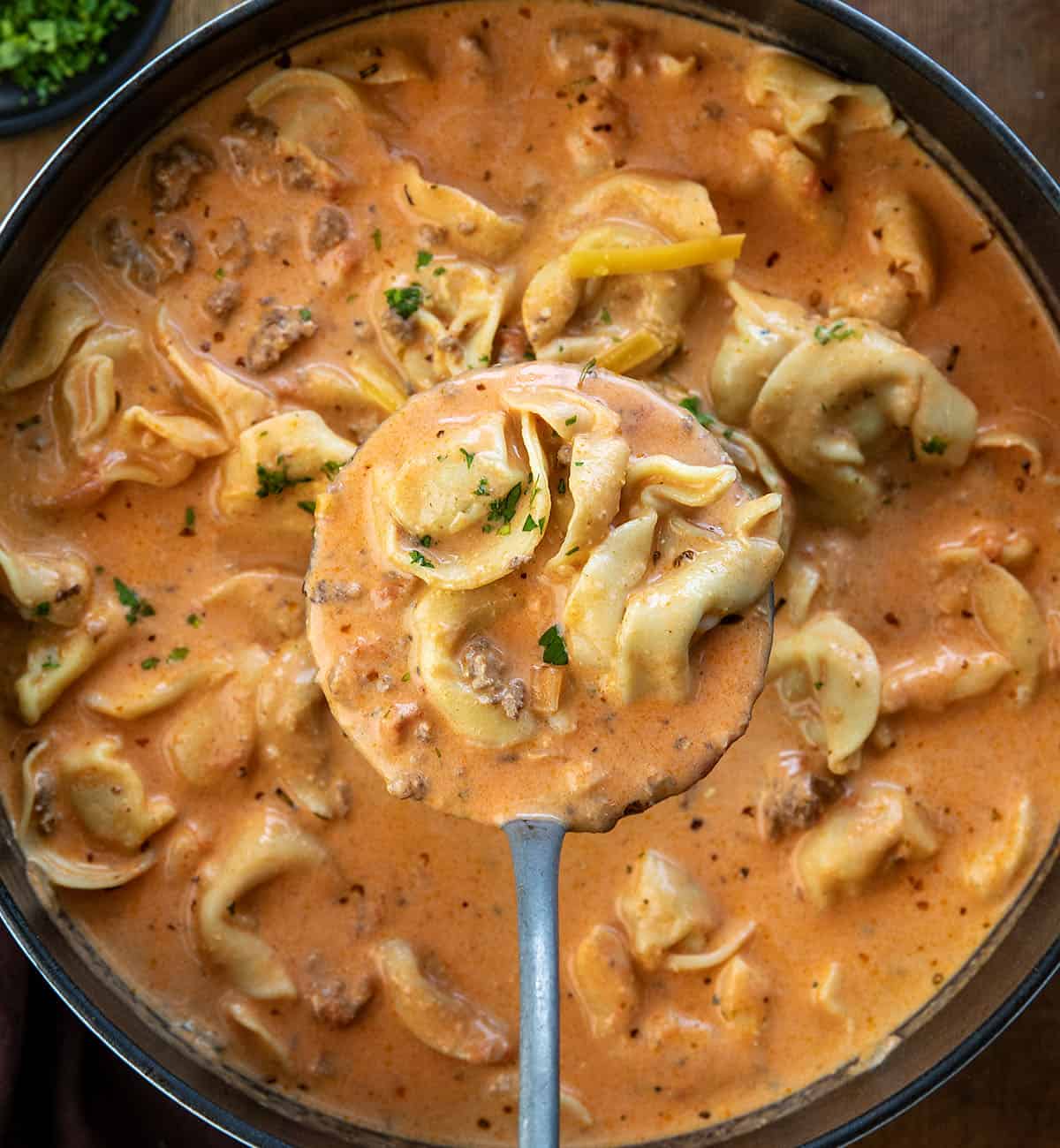 Ladle full of Cheesy Hamburger Tortellini Soup being held above the pot Ladle full of Cheesy Hamburger Tortellini Soup being held above the pot.