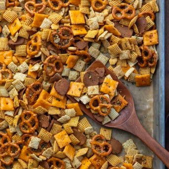 Cowboy Butter Chex Mix in a pan with a wooden spatula.