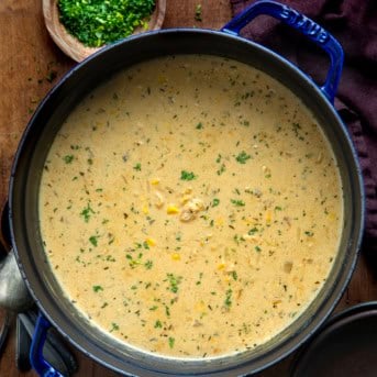 Pot of Creamy Chicken Corn Orzo Soup on a wooden table from overhead.