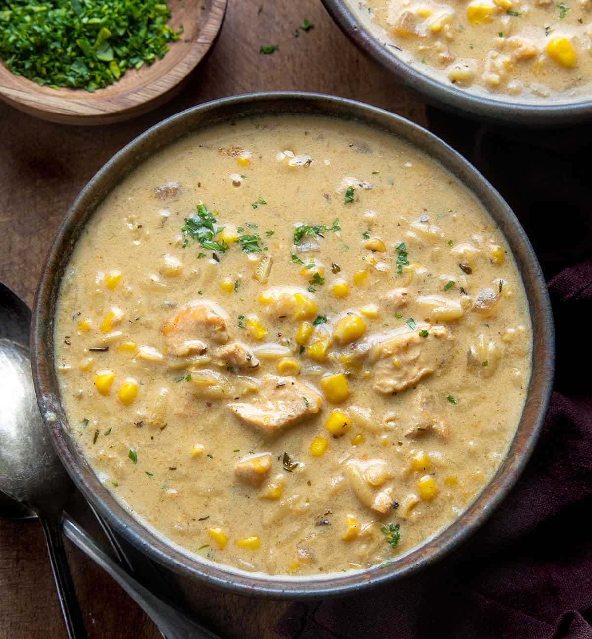 Bowl of Creamy Chicken Corn Orzo Soup on a wooden table from overhead Bowl of Creamy Chicken Corn Orzo Soup on a wooden table from overhead.