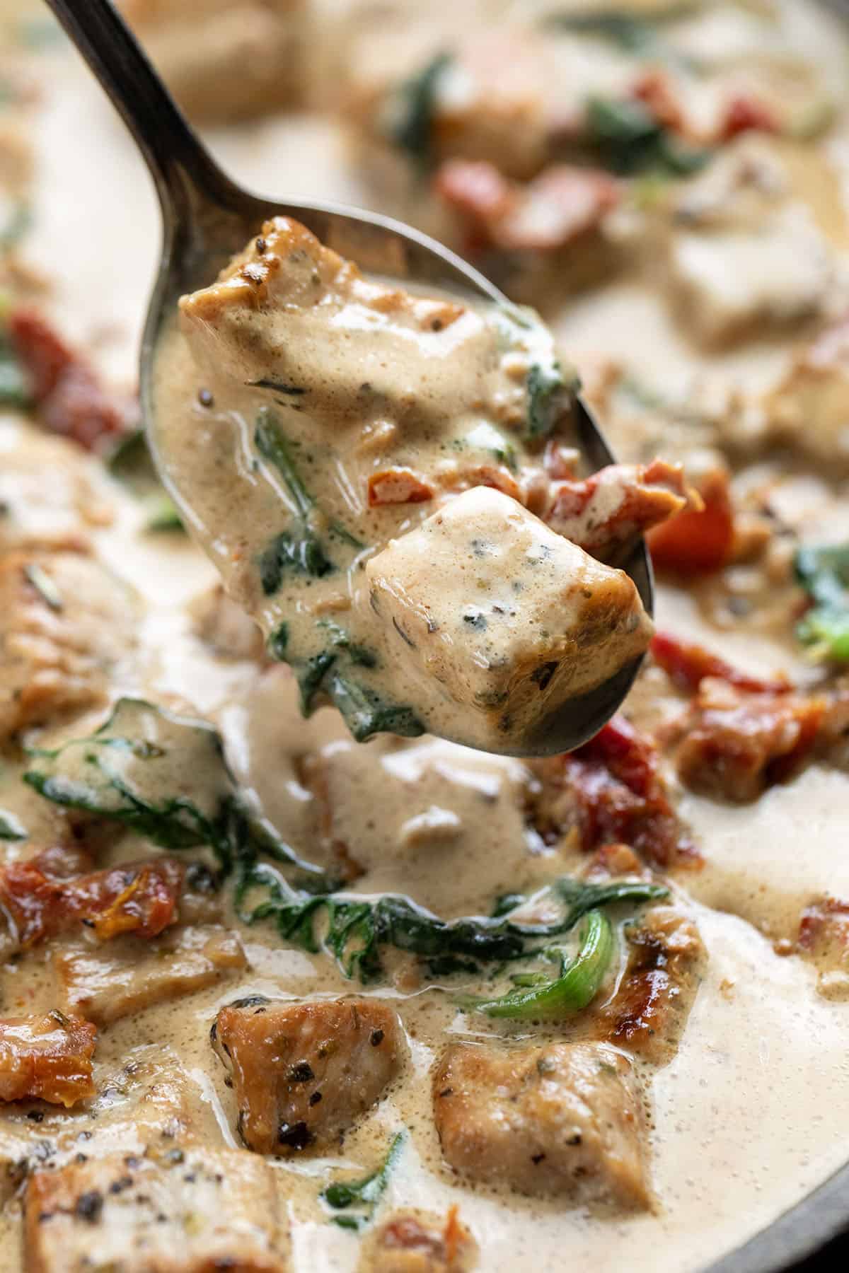 Close up of a spoonful of Creamy Tuscan Pork Bites Close up of a spoonful of Creamy Tuscan Pork Bites.