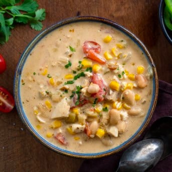 Creamy White Bean Chicken Chili in a blue bowl on a wooden table from overhead.