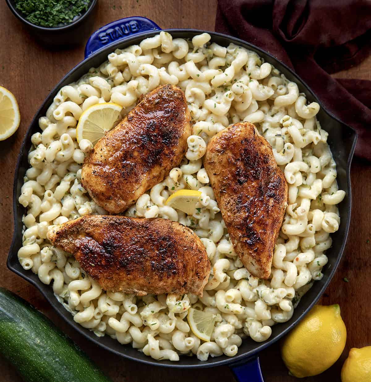 Skillet of Garlic Lemon Chicken Zucchini Pasta on a wooden table from overhead Skillet of Garlic Lemon Chicken Zucchini Pasta on a wooden table from overhead.