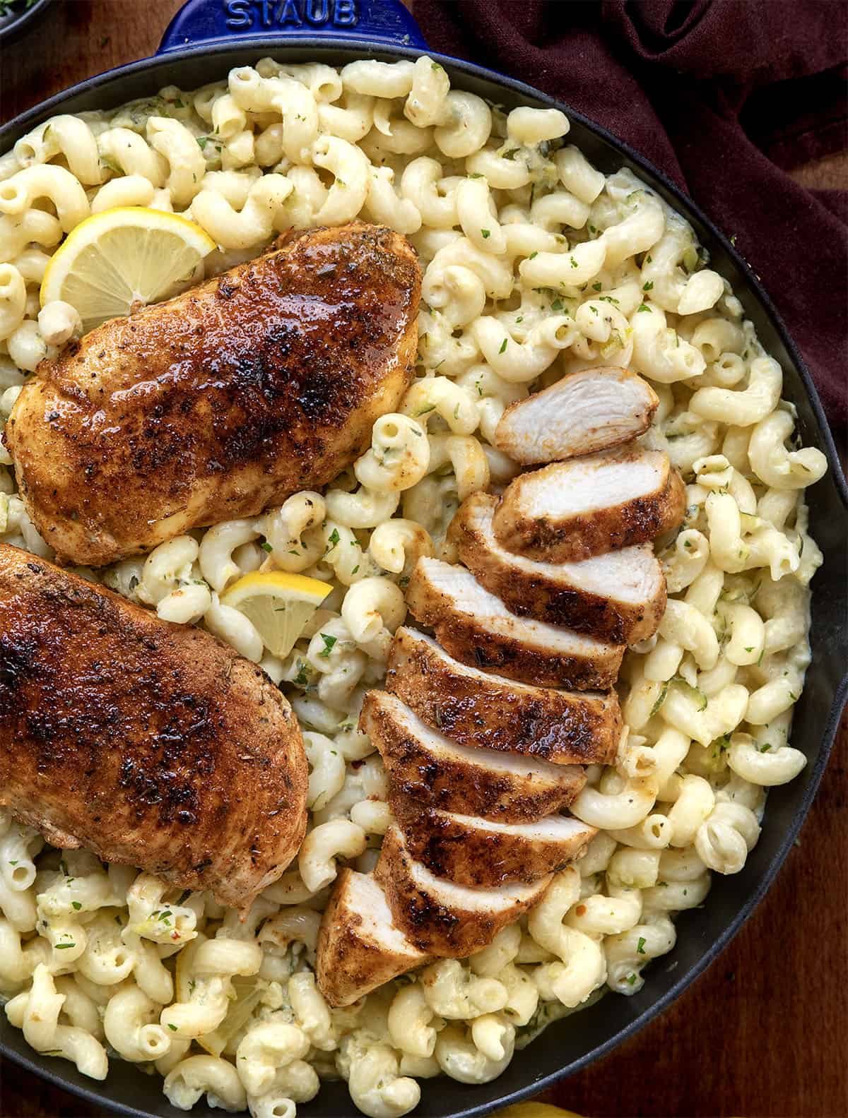 Close up of a skillet of Garlic Lemon Chicken Zucchini Pasta with one piece sliced Close up of a skillet of Garlic Lemon Chicken Zucchini Pasta with one piece sliced.