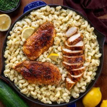 Skillet of Garlic Lemon Chicken Zucchini Pasta with three pieces of chicken and one piece is thinly sliced.