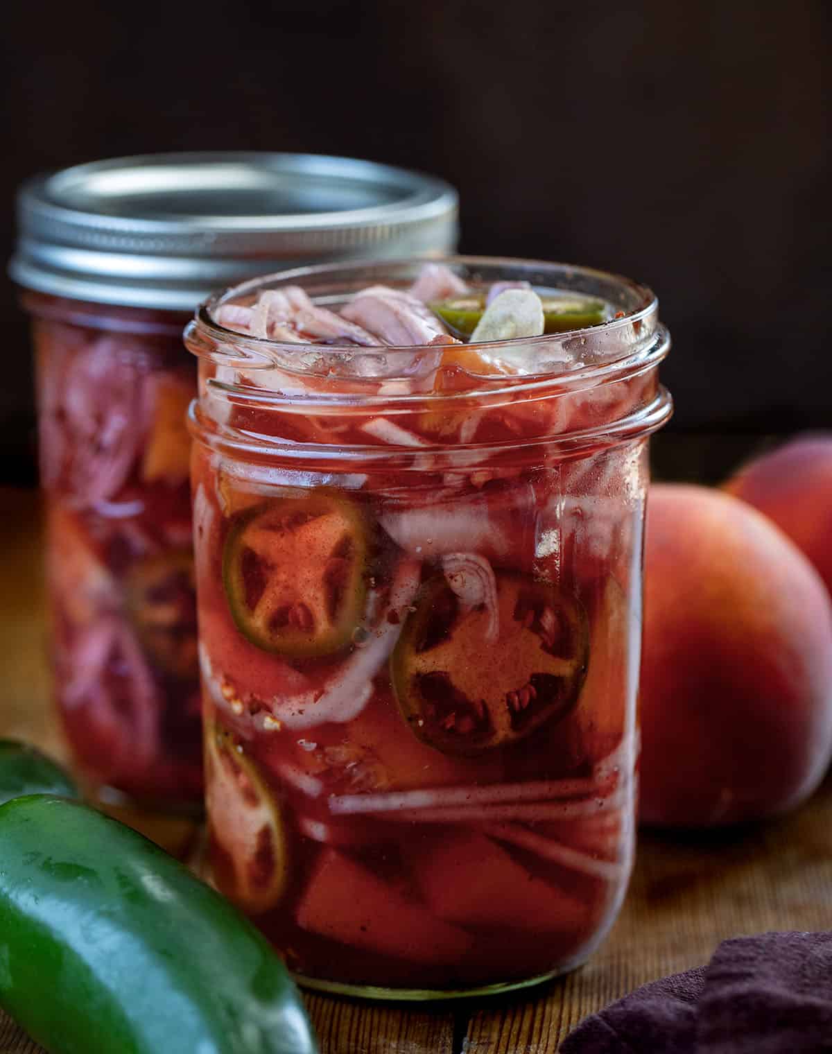 Two jars of Jalapeño Peach Pickled Onions with one jar open Two jars of Jalapeño Peach Pickled Onions with one jar open.