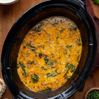 Slow Cooker Tuscan White Bean Soup on a wooden table from overhead.