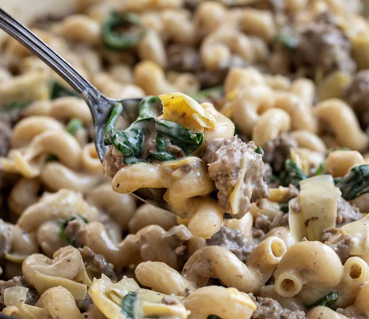 Close up of a spoonful of Spinach Artichoke Hamburger Pasta Close up of a spoonful of Spinach Artichoke Hamburger Pasta.
