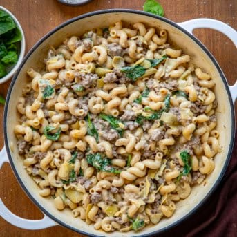 Pot of Spinach Artichoke Hamburger Pasta on a wooden table from overhead.