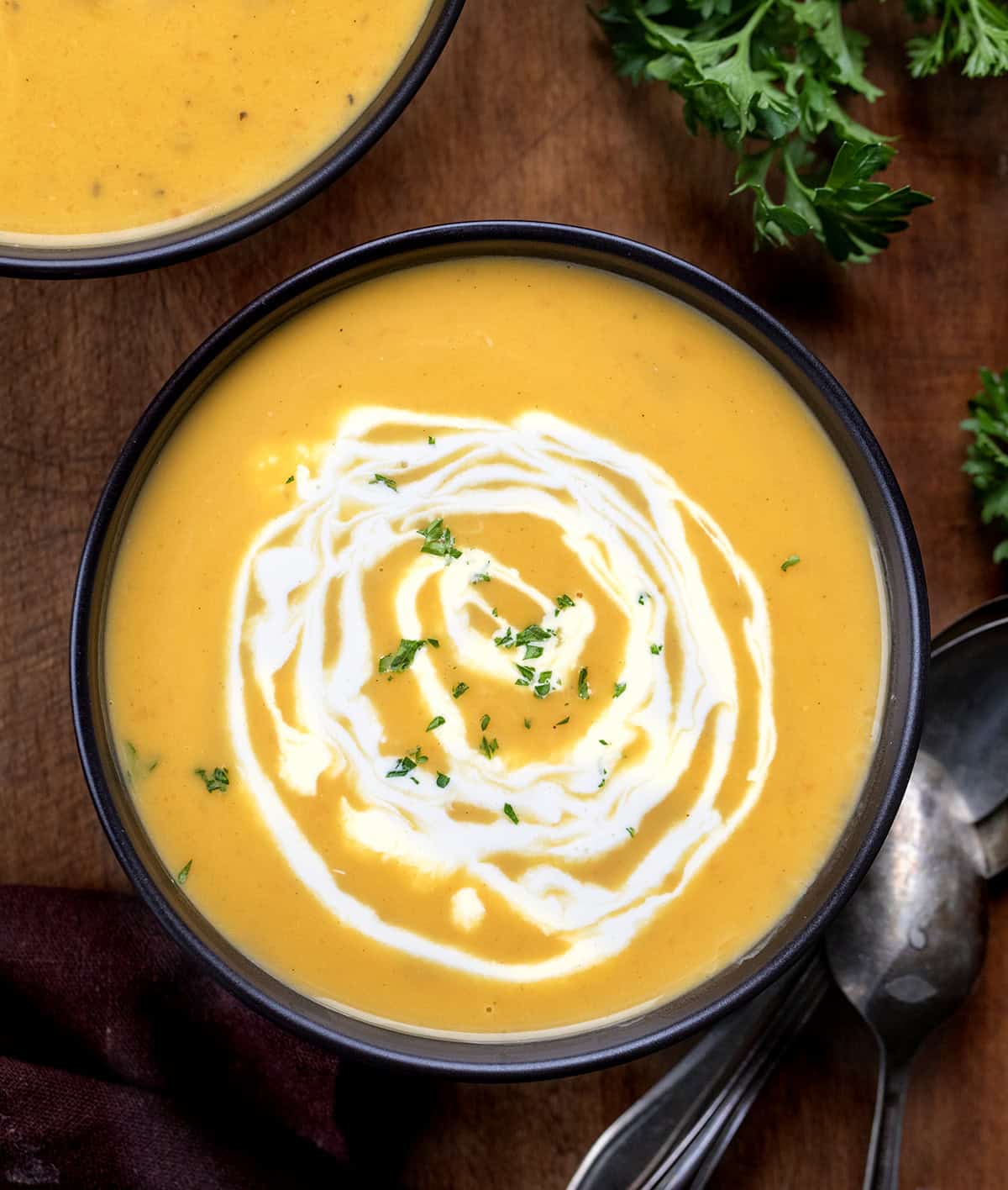 Bowls of Apple Butternut Squash Soup on a wooden table from overhead Bowls of Apple Butternut Squash Soup on a wooden table from overhead.