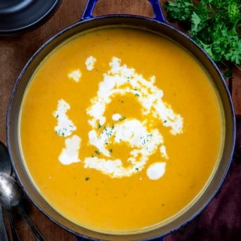 Pot of Apple Butternut Squash Soup on a wooden table from overhead.