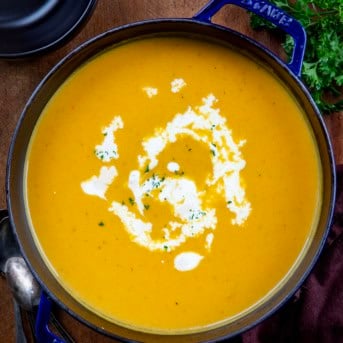 Pot of Apple Butternut Squash Soup on a wooden table from overhead.