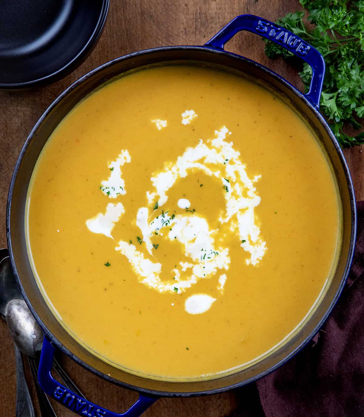 Pot of Apple Butternut Squash Soup on a wooden table from overhead Pot of Apple Butternut Squash Soup on a wooden table from overhead.