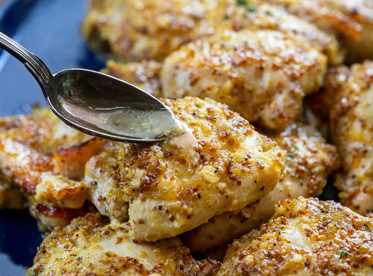 Spooning sauce over Baked Honey Mustard Chicken Thighs Spooning sauce over Baked Honey Mustard Chicken Thighs.