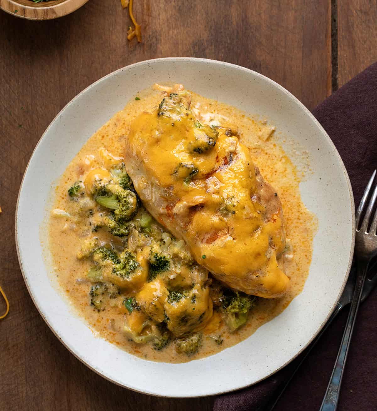 Broccoli Cheddar Chicken Casserole on a plate on a wooden table from overhead Broccoli Cheddar Chicken Casserole on a plate on a wooden table from overhead.