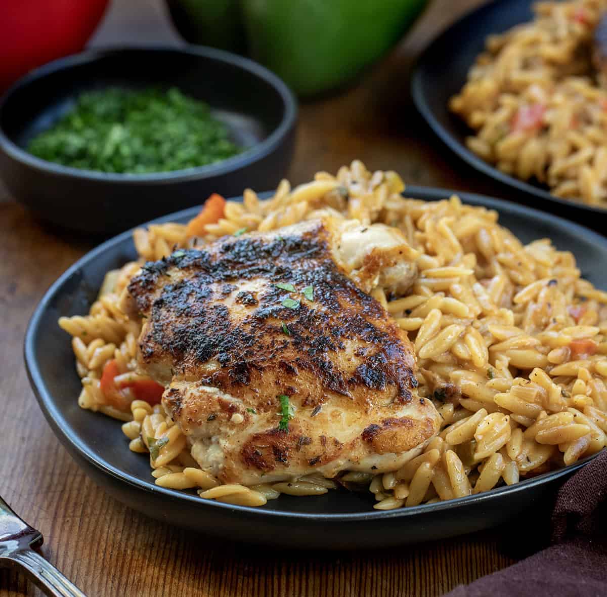 Cajun Chicken Orzo on a black plate close up Cajun Chicken Orzo on a black plate close up.