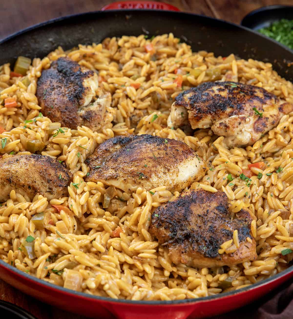 Close up of cajun chicken nestled into creamy orzo in a skillet Close up of cajun chicken nestled into creamy orzo in a skillet.