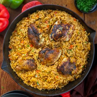 Skillet of Cajun Chicken Orzo on a wooden table from overhead.