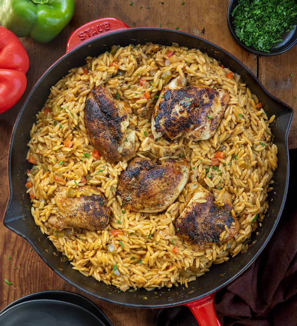 Skillet of Cajun Chicken Orzo on a wooden table from overhead Skillet of Cajun Chicken Orzo on a wooden table from overhead.