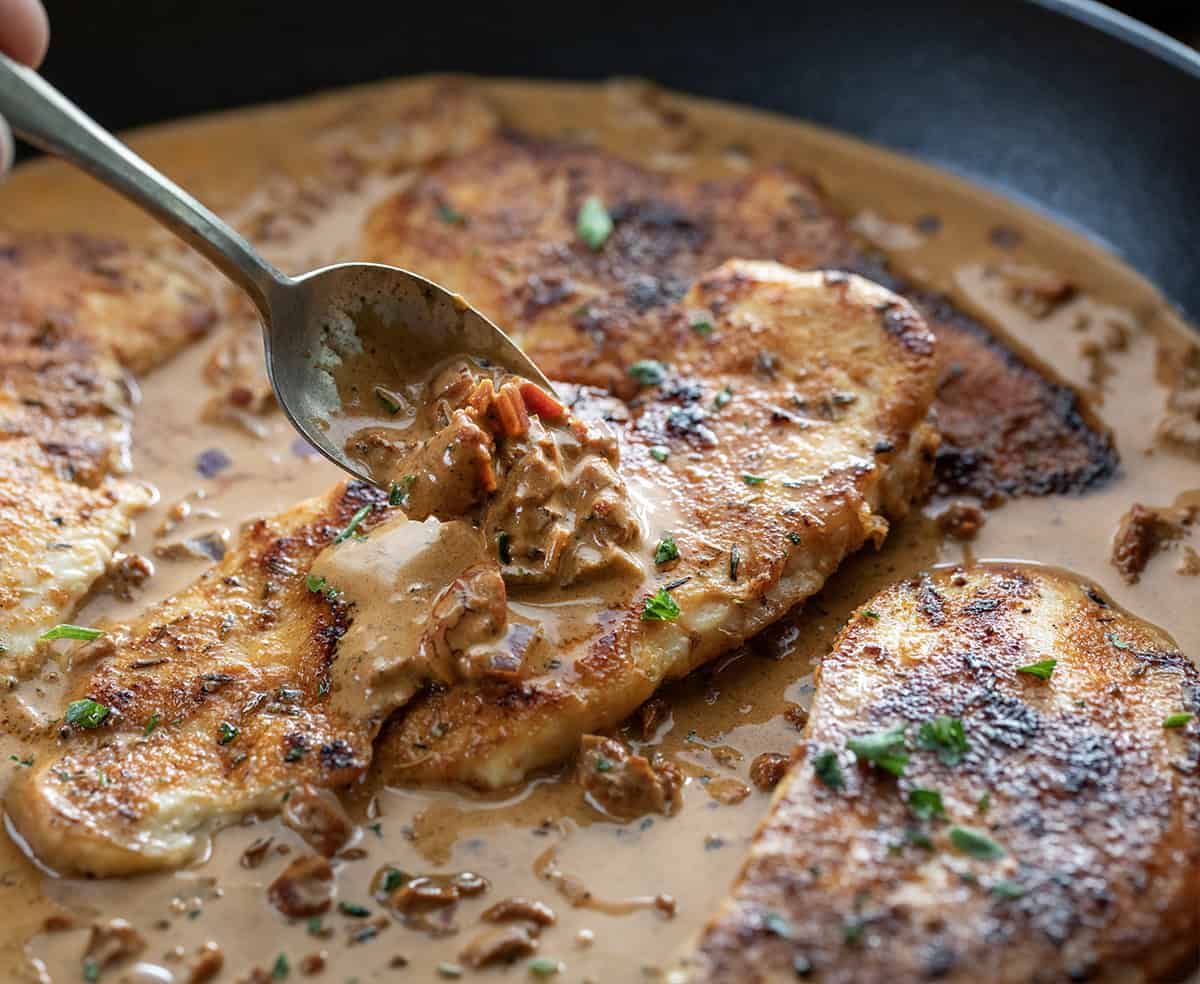 Spooning sauce over a piece of Creamy Paprika Chicken Spooning sauce over a piece of Creamy Paprika Chicken.