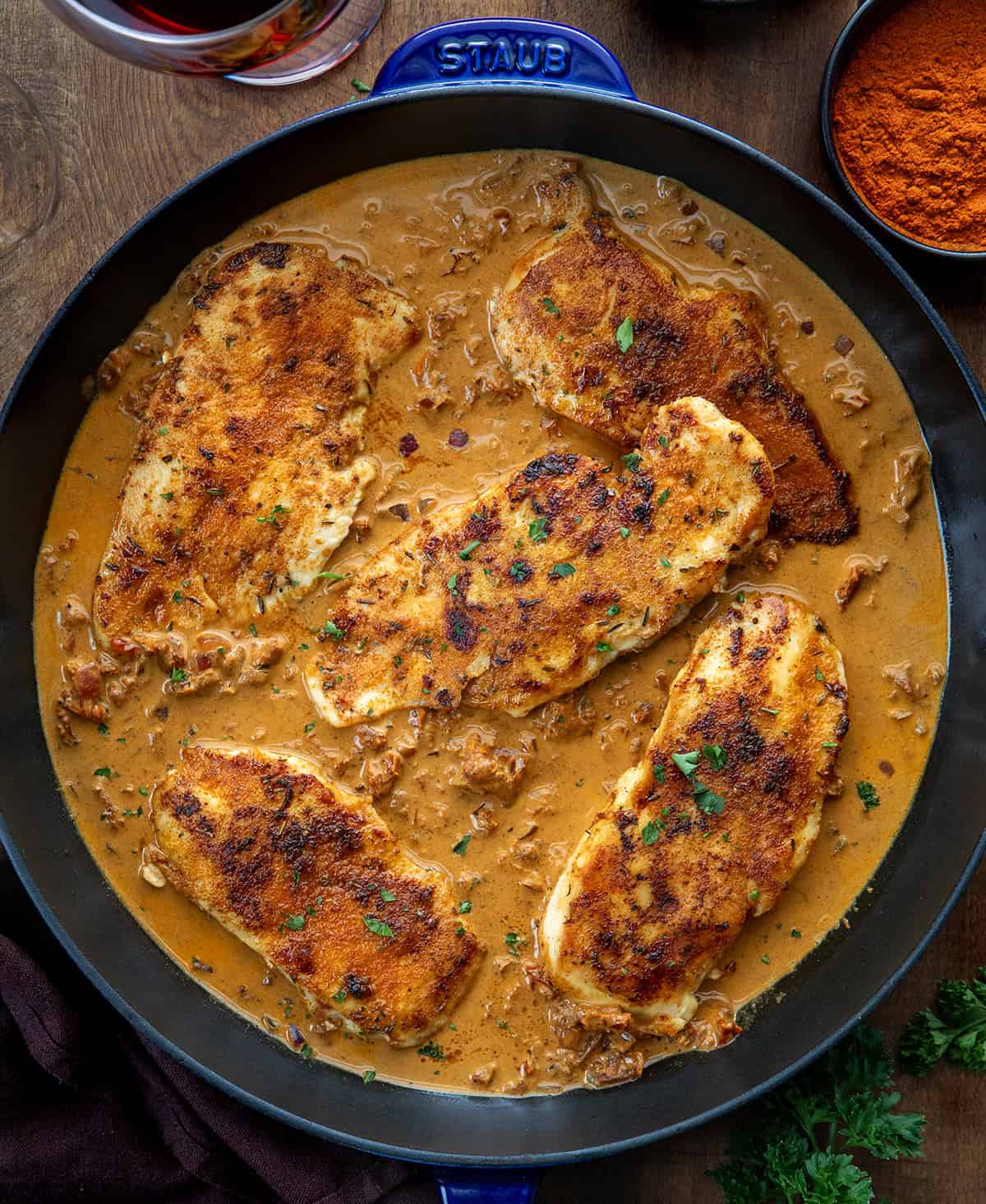 Skillet of Creamy Paprika Chicken on a wooden table from overhead Skillet of Creamy Paprika Chicken on a wooden table from overhead.