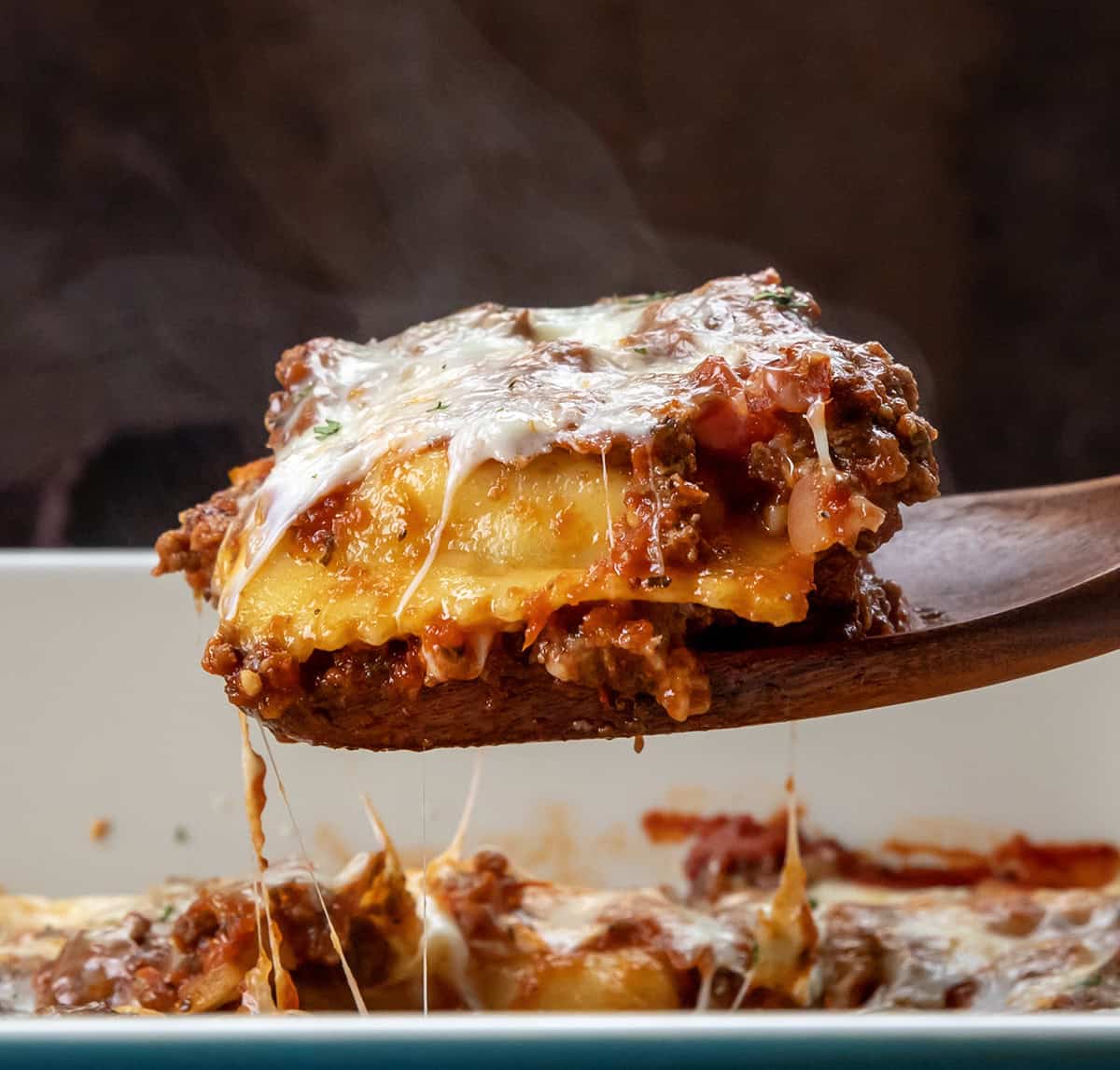 Wooden spoon picking up a portion of Easy Baked Ravioli from the pan Wooden spoon picking up a portion of Easy Baked Ravioli from the pan.