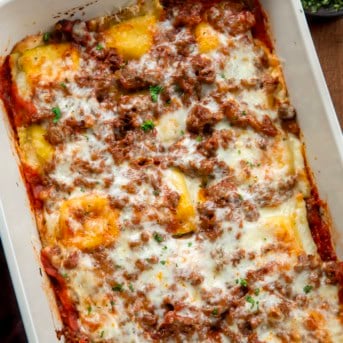 Close up of a pan of Easy Baked Ravioli on a wooden table.