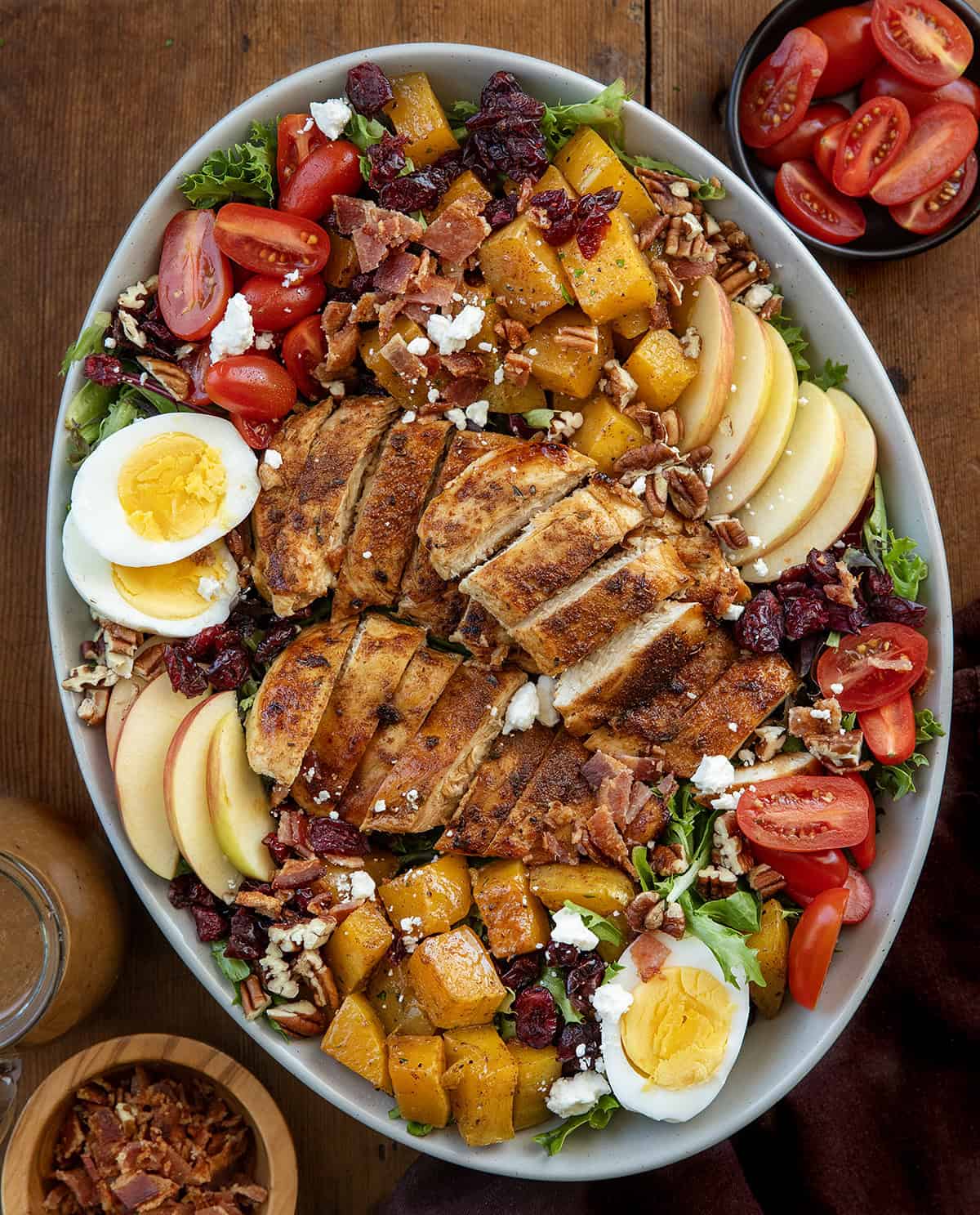 Harvest Chicken Salad in a serving platter before being mixed together on a wooden table from overhead.