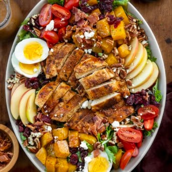 Harvest Chicken Salad in a serving platter before being mixed together on a wooden table from overhead.