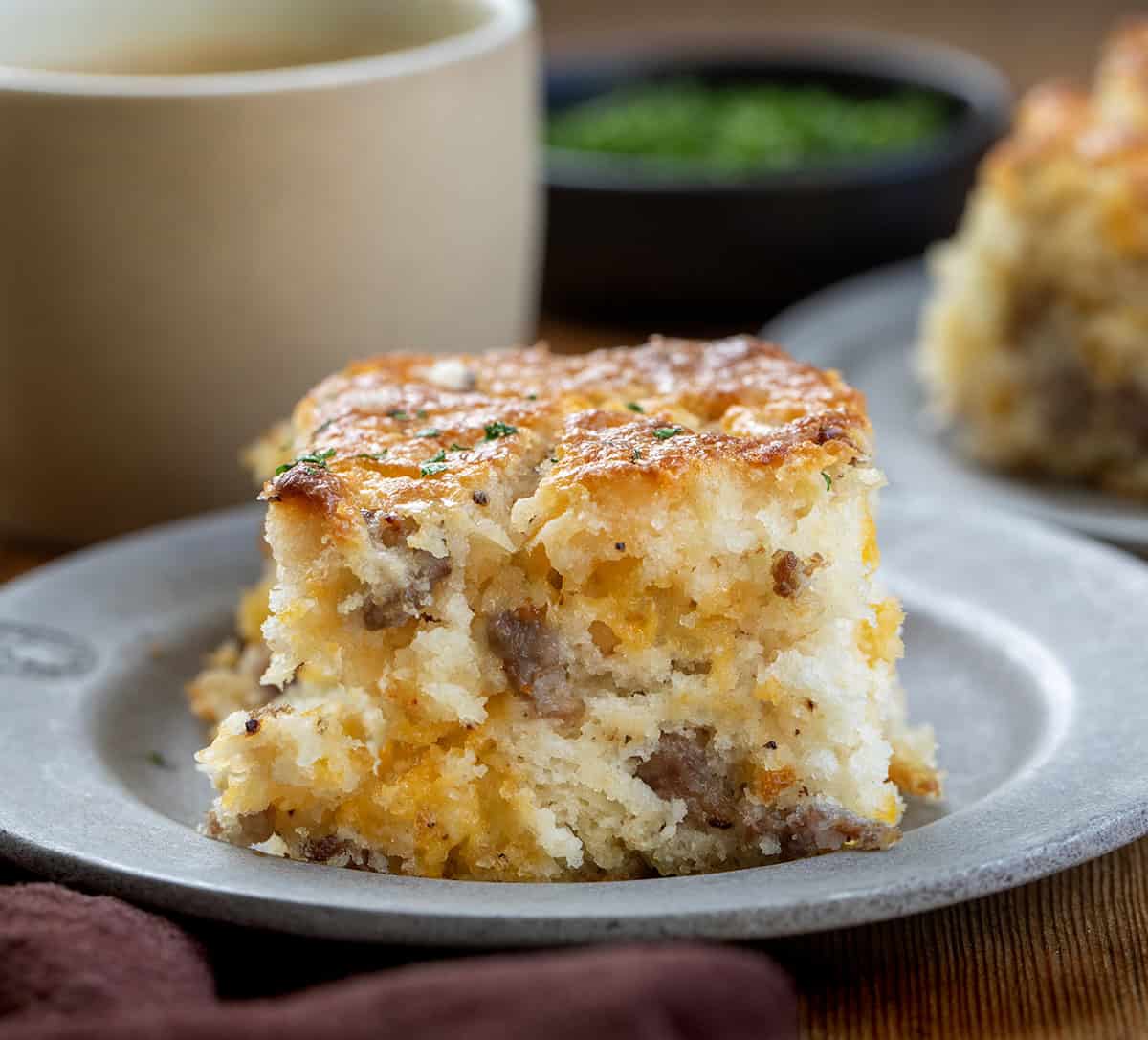 Breakfast Maple Sausage Butter Swim Biscuit on a plate on a wooden table with coffee Breakfast Maple Sausage Butter Swim Biscuit on a plate on a wooden table with coffee.