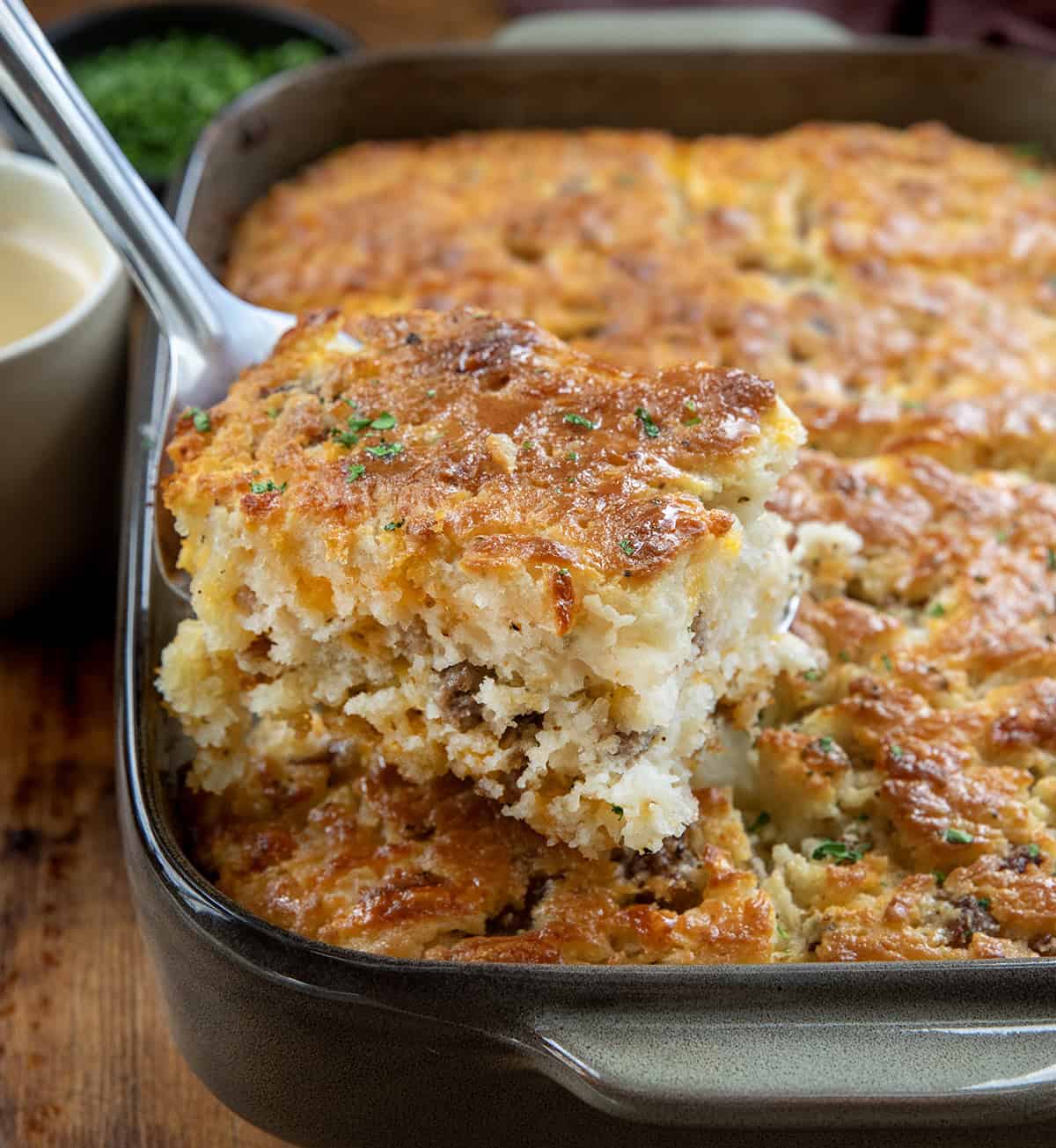 Spatula picking up a Maple Sausage Butter Swim Biscuit from the pan Spatula picking up a Maple Sausage Butter Swim Biscuit from the pan.