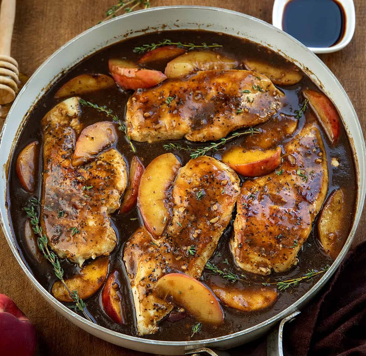 Peach Balsamic Chicken in a skillet on a wooden table close up Peach Balsamic Chicken in a skillet on a wooden table close up.