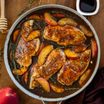 Peach Balsamic Chicken in a skillet on a wooden table from overhead.