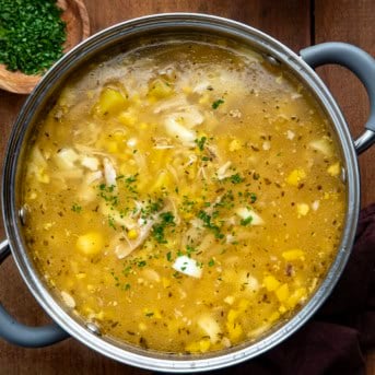 Pennsylvania Dutch Chicken Corn Soup in a pot on a wooden table from overhead.