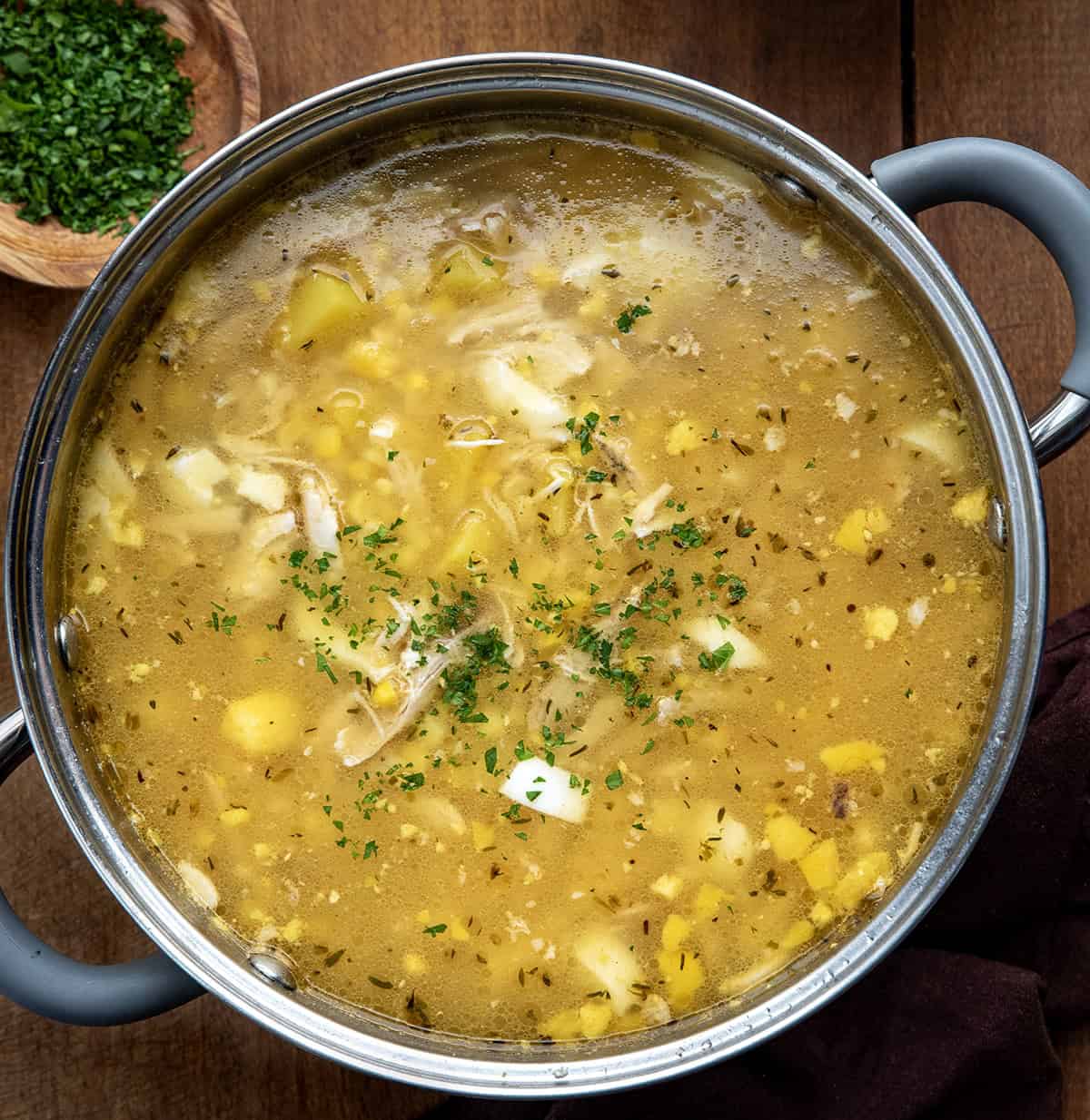 Pennsylvania Dutch Chicken Corn Soup in a pot on a wooden table from overhead Pennsylvania Dutch Chicken Corn Soup in a pot on a wooden table from overhead.