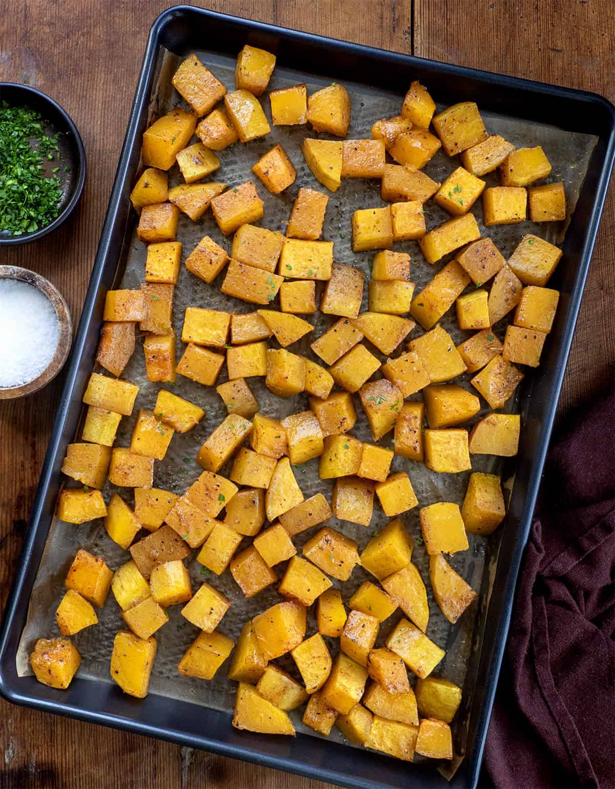 Sheet pan of Roasted Butternut Squash on a wooden table from overhead Sheet pan of Roasted Butternut Squash on a wooden table from overhead.