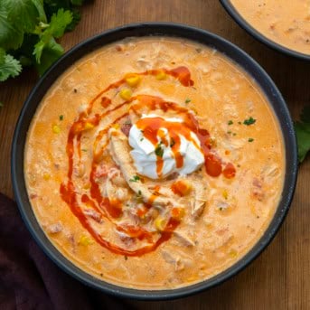 Bowls of Slow Cooker Buffalo Chicken Soup on a wooden table from overhead.