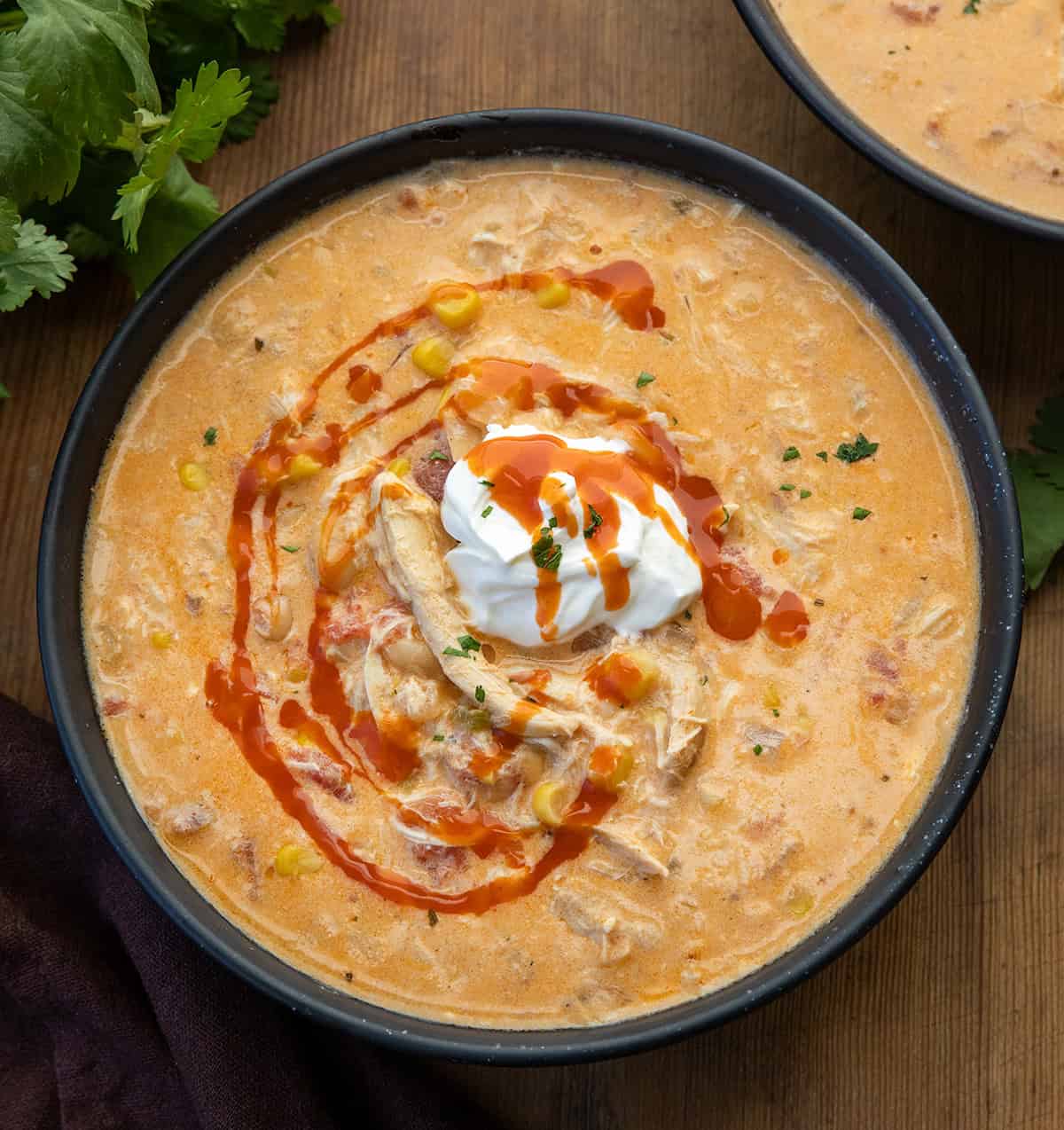 Bowls of Slow Cooker Buffalo Chicken Soup on a wooden table from overhead Bowls of Slow Cooker Buffalo Chicken Soup on a wooden table from overhead.