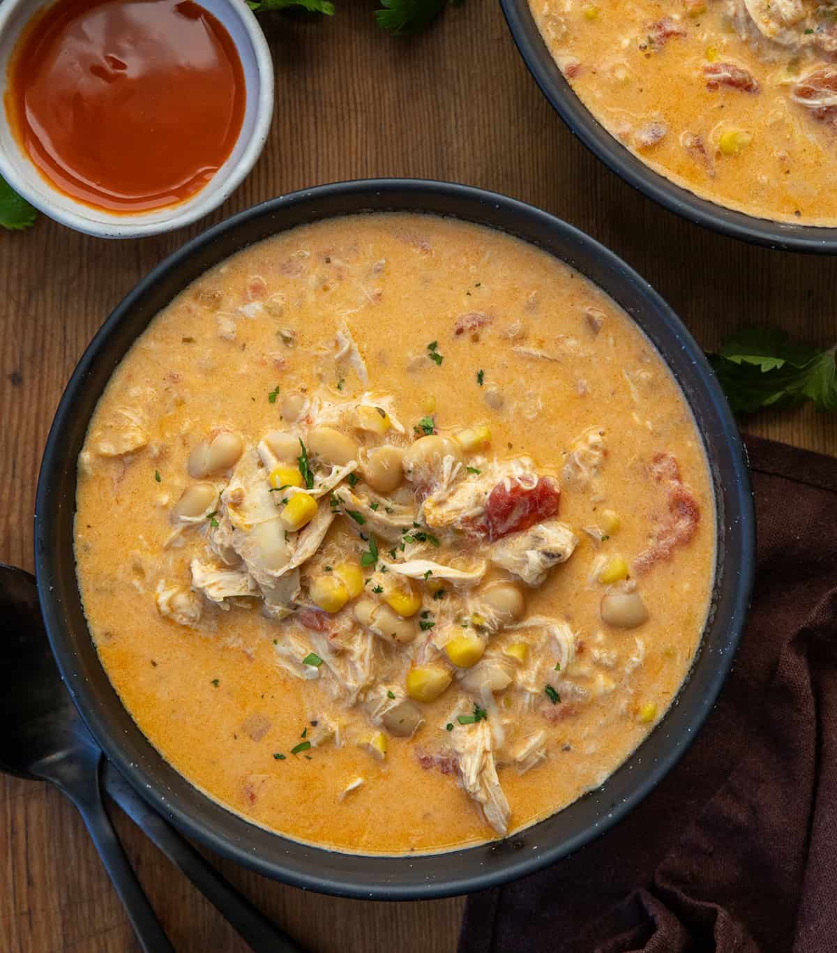 Black bowls of Slow Cooker Buffalo Chicken Soup on a wooden table from overhead Black bowls of Slow Cooker Buffalo Chicken Soup on a wooden table from overhead.