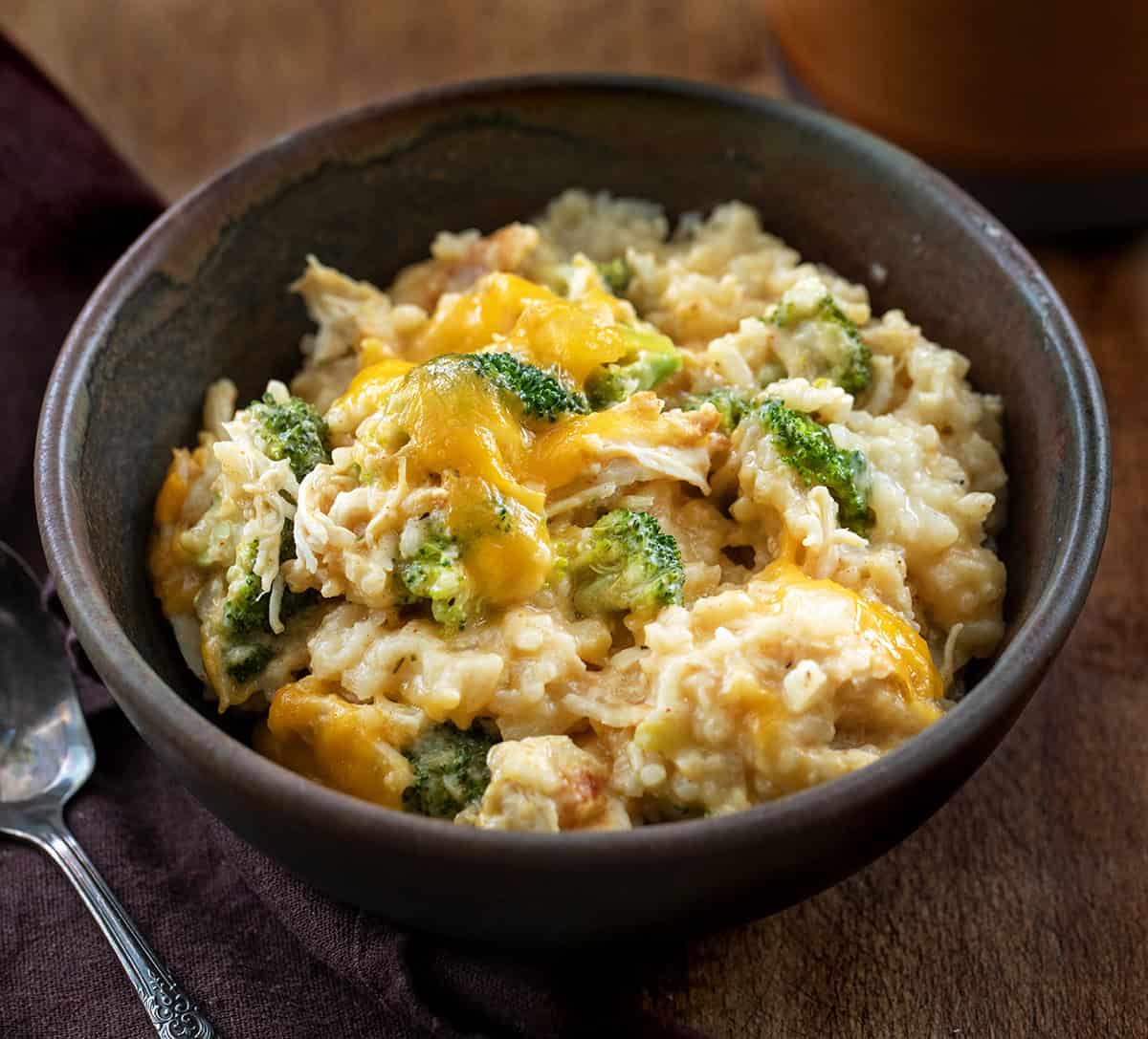 Bowl of Slow Cooker Chicken Broccoli and Rice on a wooden table Bowl of Slow Cooker Chicken Broccoli and Rice on a wooden table.