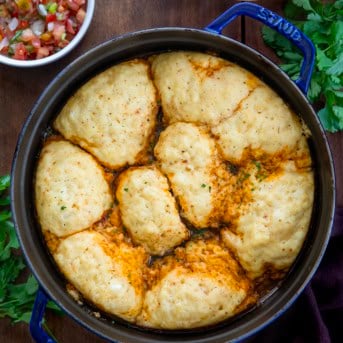 Pot of Southwest Chicken and Dumplings on a wooden table from overhead.