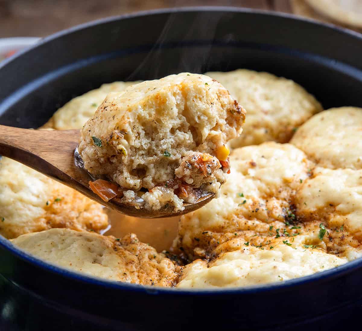 Wooden spoon picking up a portion of Southwest Chicken and Dumplings from the pot Wooden spoon picking up a portion of Southwest Chicken and Dumplings from the pot.