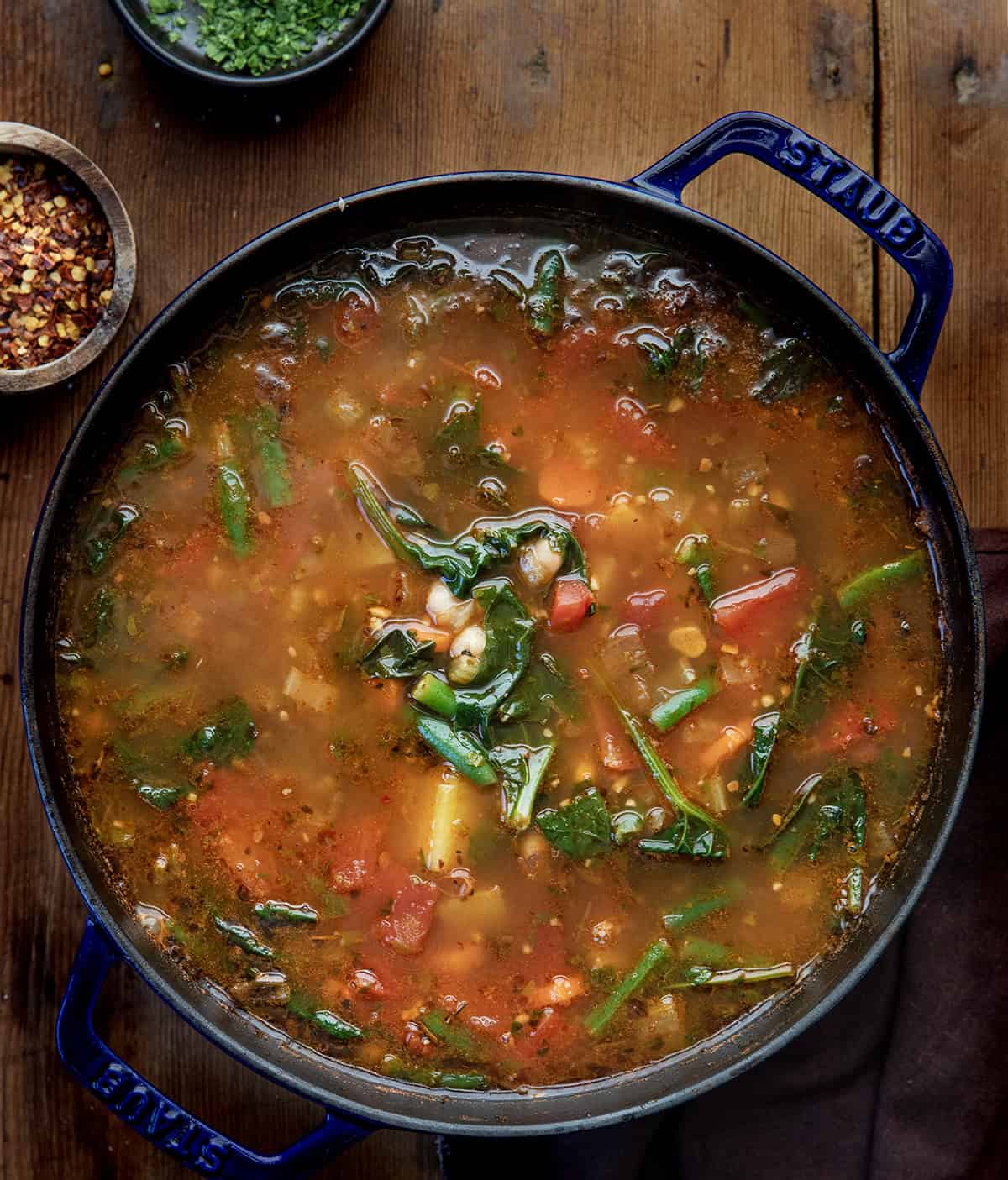 Pot of Vegetable Soup on a wooden table from overhead Pot of Vegetable Soup on a wooden table from overhead.