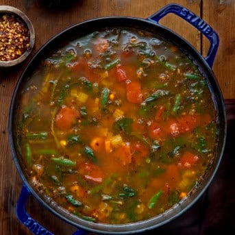 Pot of Vegetable Soup on a wooden table from overhead.