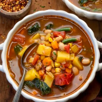 Bowls of Vegetable Soup on a wooden table.